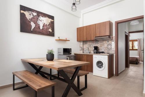a kitchen with a table and a washing machine at Utopia Suites in Egina