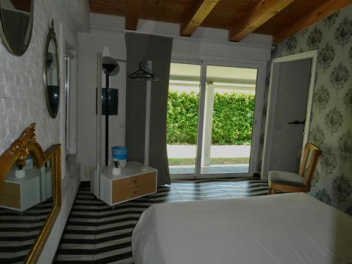 a bedroom with a bed and a chair and a window at Orchidea in Beverino