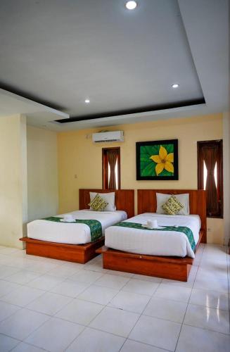 a bedroom with two beds in a room at Melati resort kuta lombok in Kuta Lombok