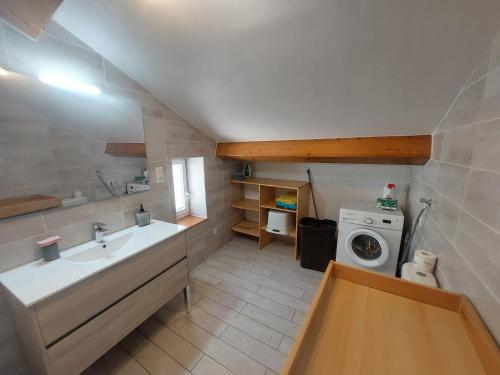 a bathroom with a sink and a washing machine at La Fontchaude, gîte de charme au cœur de la nature à Cabrespine in Cabrespine
