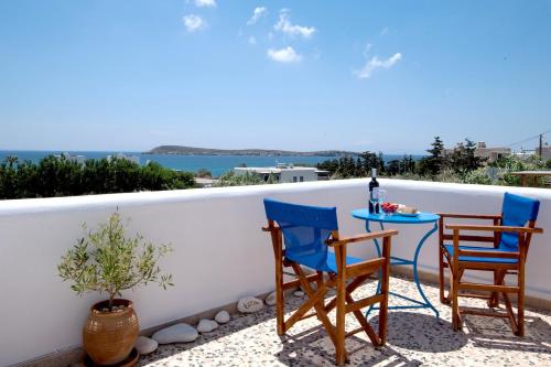 two chairs and a table on a balcony at Flora & Agelos Studios - Paros in Chrissi Akti