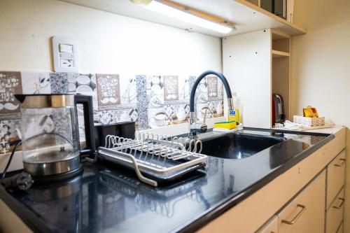 a kitchen with a sink and a dish drying rack at HYGGE FORMOSA in Formosa