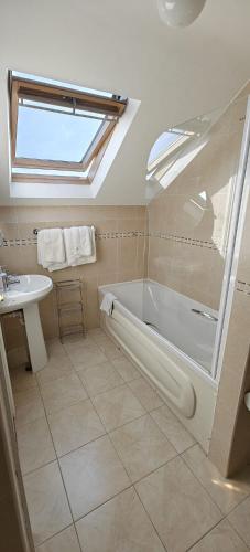 a bathroom with a bath tub and a sink at Sli Na Mara in Galway