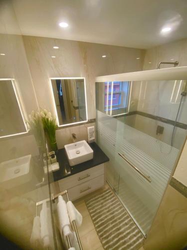 a bathroom with a glass shower and a sink at Jaden's Guest House in Saint Michael