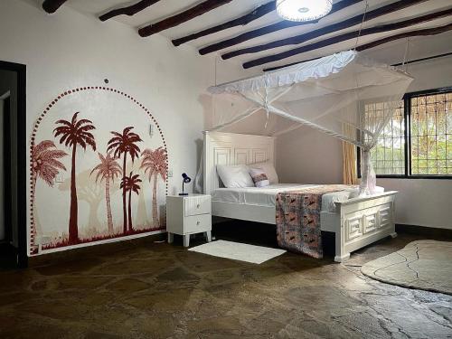 a bedroom with a canopy bed with palm trees on the wall at Malindi Mambrui Villa in Malindi