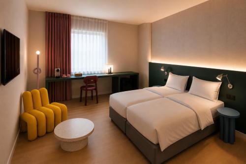 a hotel room with a bed and a desk at Hôtel Les Loges in Geneva