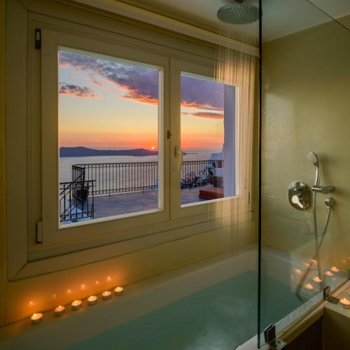 a bathroom with a window with a view of the ocean at Kamares Neoklassiko in Fira
