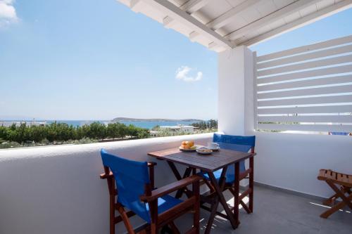 a table and chairs on a balcony with a view at Flora & Agelos Studios - Paros in Chrissi Akti