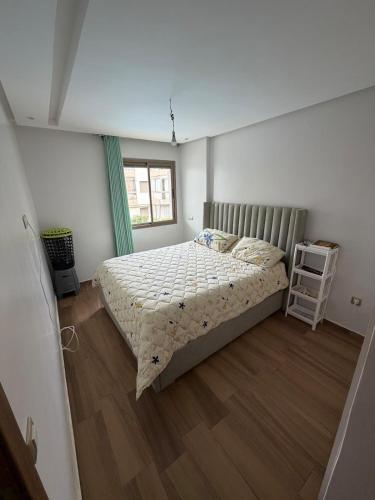 a bedroom with a bed and a wooden floor at Odyssée Atlantique Blue beach - Sidi Rahal - famille seulement in Sidi Rahal