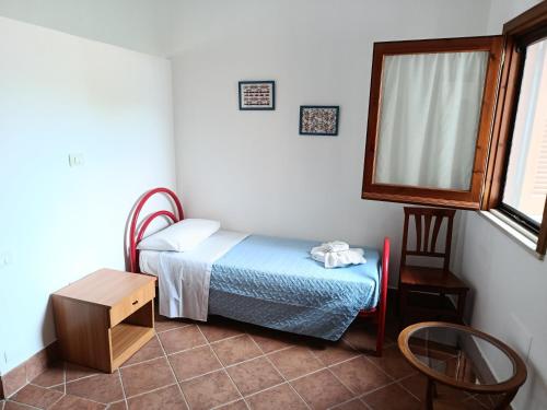 a small bedroom with a small bed and a table at Accomodation Villa Florio Parghelia in Fitili