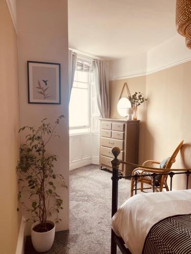 a bedroom with a bed and a table and a chair at Stunning seafront apartment in Brighton & Hove