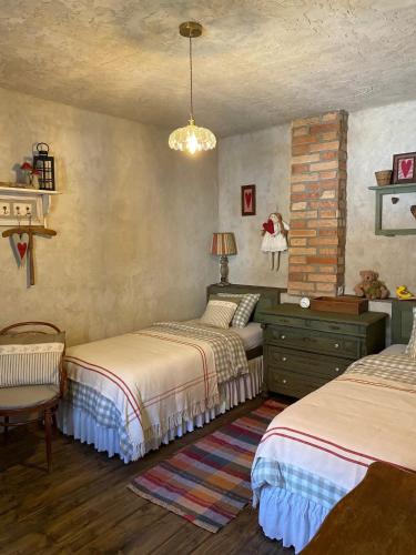a bedroom with two beds and a chandelier at Chalupa u babičky in Salka