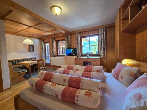 a living room with a bed and a dining room at Orterhof in Obertilliach