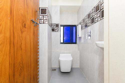 a bathroom with a toilet and a window at Hotel Platinum in Mumbai