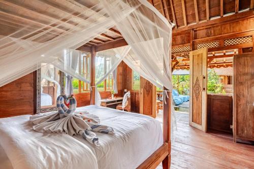 a bedroom with a canopy bed with towels on it at Green Labak 1 in Silebeng
