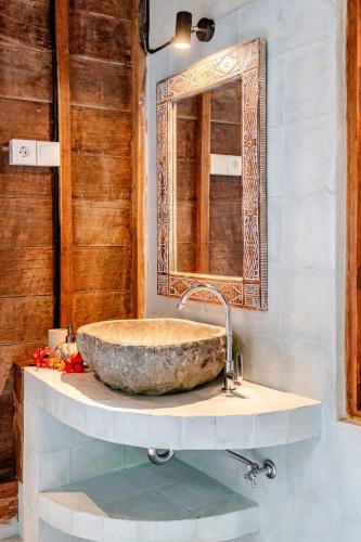 a bathroom with a stone sink and a mirror at Green Labak 1 in Silebeng