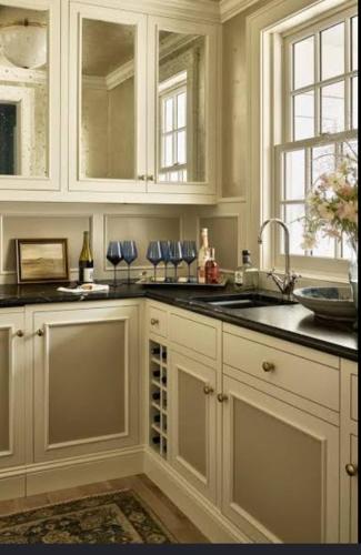 a kitchen with white cabinets and a sink at Sheena Apartment in Manila