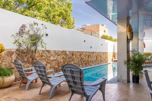 a patio with chairs and a swimming pool at Olas del Mar Hotel by GHO Hoteles in Santa Marta