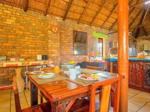 a kitchen with a wooden table with food on it at Airport Bird & Game Lodge in Kempton Park
