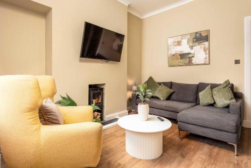 a living room with a couch and a tv at Scott Suite - Donnini Apartments in Kilmarnock