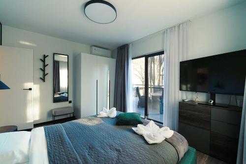 a bedroom with a large bed and a large window at Paltinu Lake Villas in Teşila