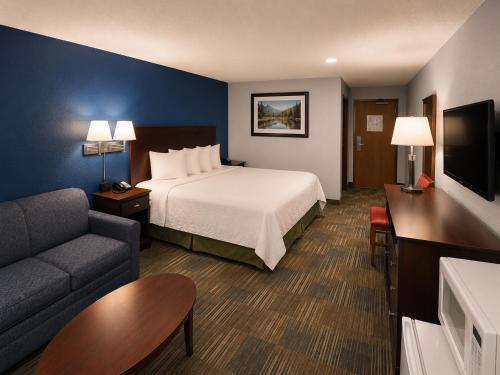 ein Hotelzimmer mit einem Bett und einer Couch in der Unterkunft Corning Inn in Painted Post