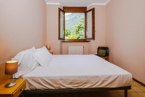 a bedroom with a white bed and a window at Villa Luzzago in Ponte di Legno