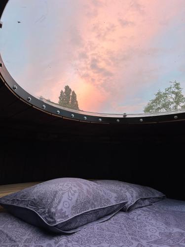 a pillow sitting on a bed in front of a window at Foudre Insolite in Naujan-et-Postiac