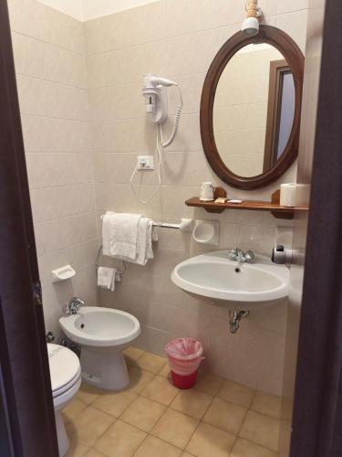 a bathroom with a sink and a toilet and a mirror at Villa Luzzago in Ponte di Legno