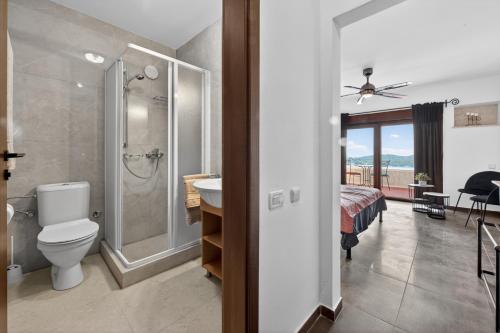 a bathroom with a toilet and a shower and a bedroom at Villa Konstantina in Orasac