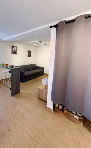 a living room with a couch and a table at Studio avec Wi-Fi, à 5mn de la Centrale du Bugey in Loyettes