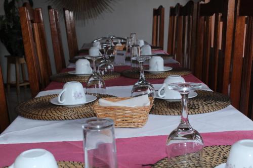 a long table with plates and wine glasses on it at Residencial Beleza in Mindelo