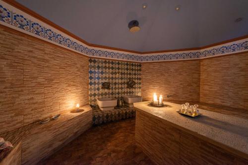 a bathroom with a tub and a toilet and candles at Leda Hamam House in Plomari
