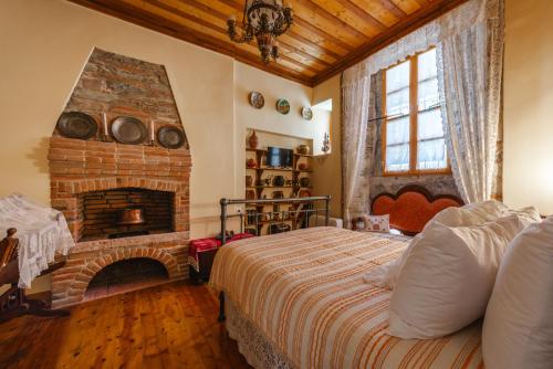 a bedroom with a bed and a brick fireplace at Leda Hamam House in Plomari