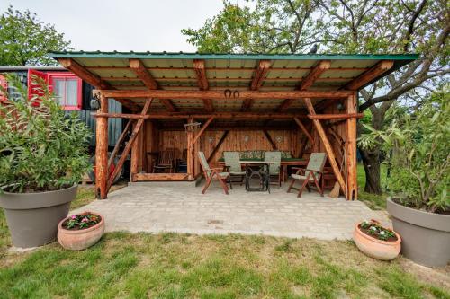 a wooden pavilion with a table and chairs in a yard at Naphegy Kuckó in Écs