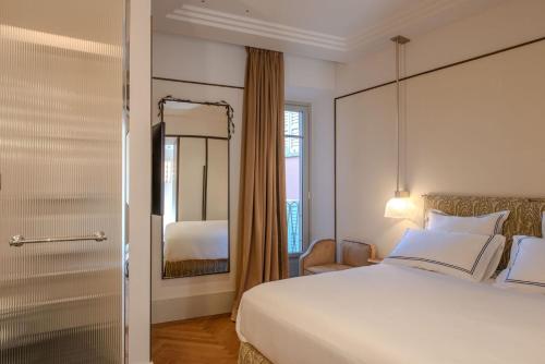 a hotel room with a bed and a mirror at Palazzo Genazzini in Bellagio