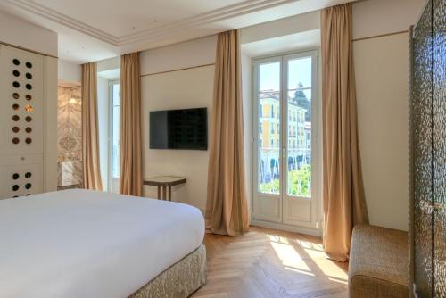 a bedroom with a bed and a large window at Palazzo Genazzini in Bellagio