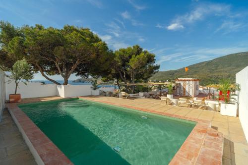 a swimming pool with a view of a villa at Hotel Cadaqués1962 by Fimedhotels in Cadaqués