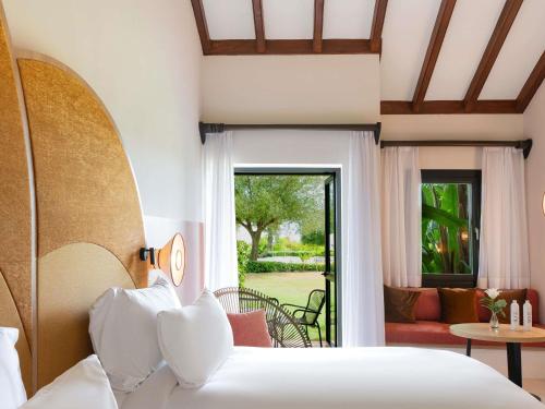 a bedroom with a bed and a living room at SO Sotogrande Spa and Golf Resort Hotel Costa del Sol in Sotogrande