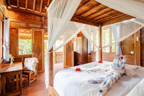 a bedroom with a white bed with a wooden ceiling at Green labak 2 in Silebeng