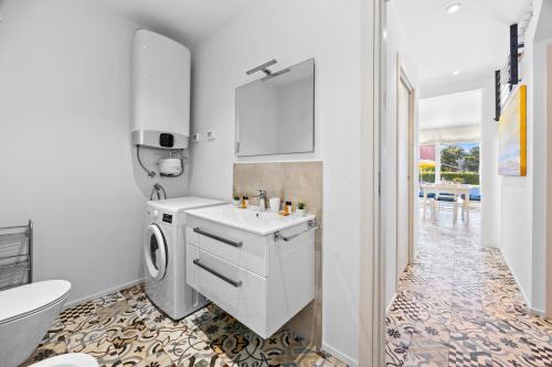 a bathroom with a sink and a washing machine at Villa del Mar in Pula