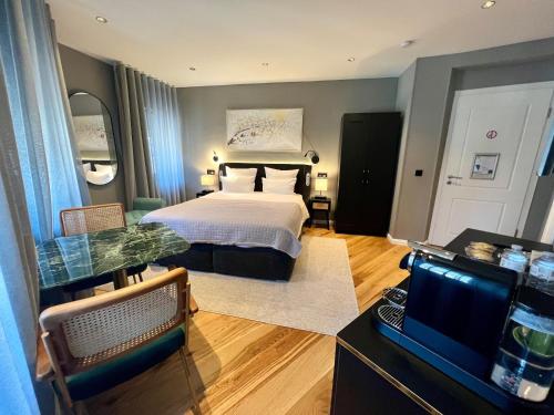 a bedroom with a bed and a desk with a television at Auberge de Vianden in Vianden