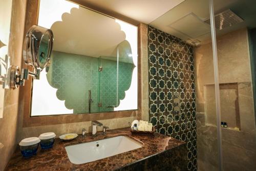 a bathroom with a sink and a mirror at Avari Lahore Hotel in Lahore