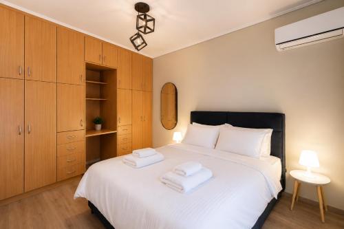 a bedroom with a white bed with two towels on it at Tyto Alba Habitat in Athens