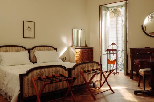 a bedroom with a bed and a mirror and a chair at La casa del Ginkgo in Bobbio