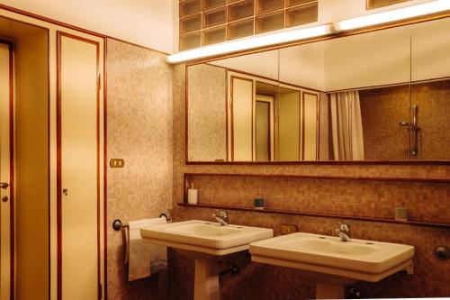 a bathroom with two sinks and a large mirror at La casa del Ginkgo in Bobbio
