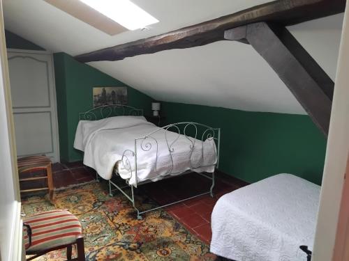 a bedroom with a bed and a green wall at Maison de charme de 8 à 13 personnes in Charlieu