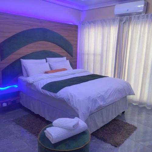 a bedroom with a large bed with a purple lighting at Exclusive guest house in Modimolle