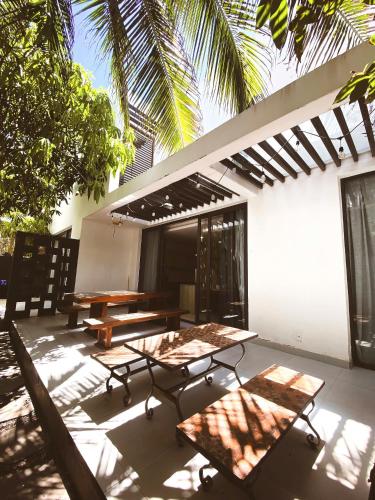 a patio with tables and benches in front of a building at Tuệ House in Ấp Gia Thanh (1)