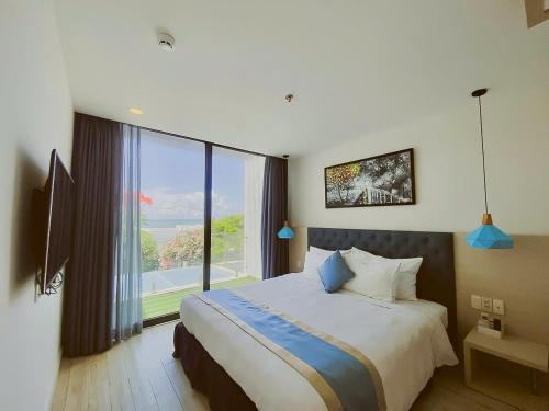 a bedroom with a large bed and a large window at Tuệ House in Ấp Gia Thanh (1)